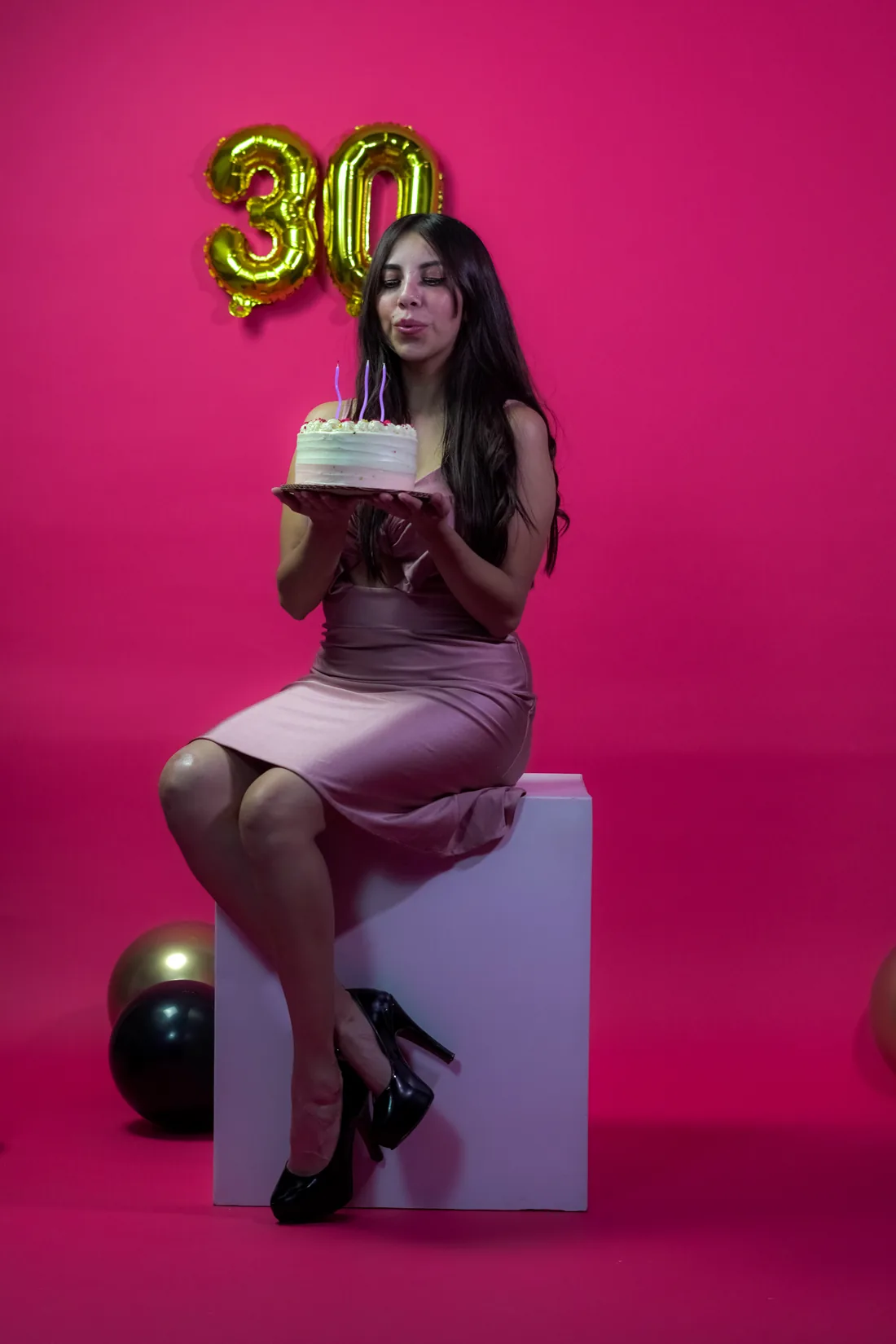 Sesión de fotos de cumpleaños en estudio con vestido rosa y números dorados sobre fondo rosa, toma 21