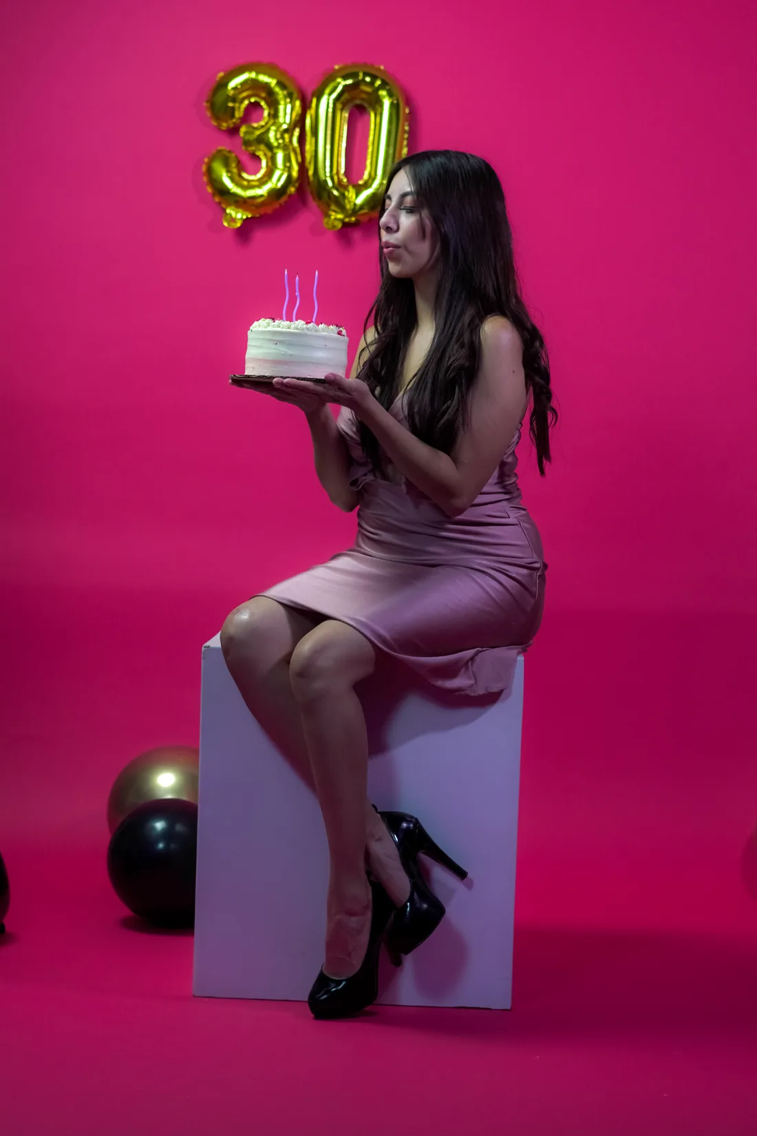 Sesión de fotos de cumpleaños en estudio con vestido rosa y números dorados sobre fondo rosa, toma 22