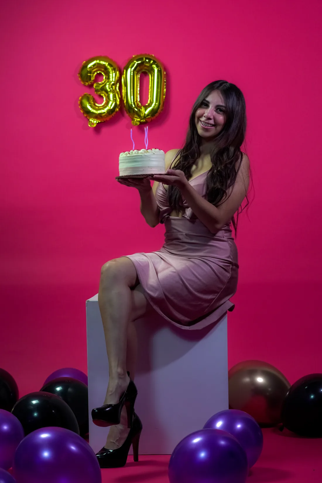 Sesión de fotos de cumpleaños en estudio con vestido rosa y números dorados sobre fondo rosa, toma 24