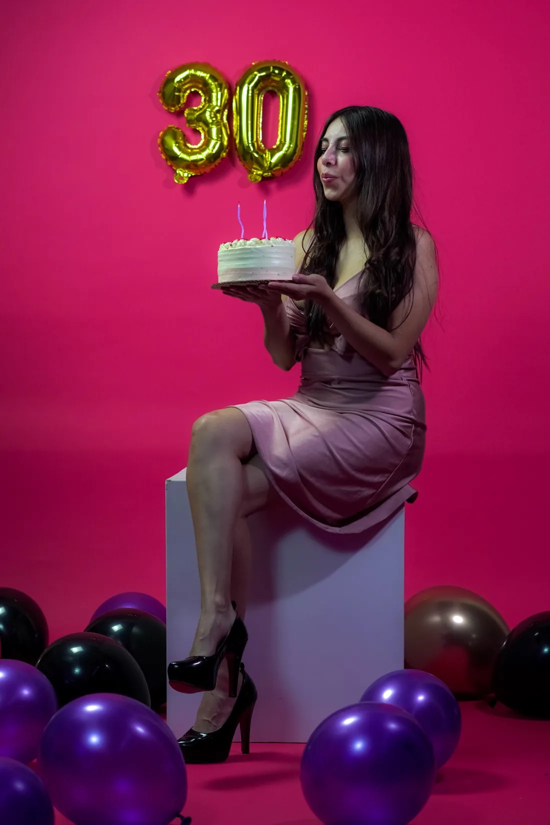 Sesión de fotos de cumpleaños en estudio con vestido rosa y números dorados sobre fondo rosa, toma 25