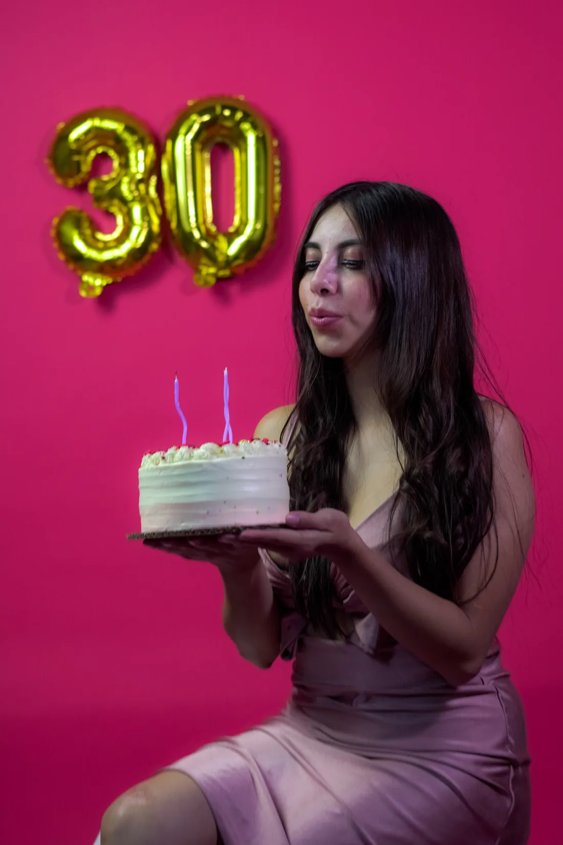 Sesión de fotos de cumpleaños en estudio con vestido rosa y números dorados sobre fondo rosa, toma 26