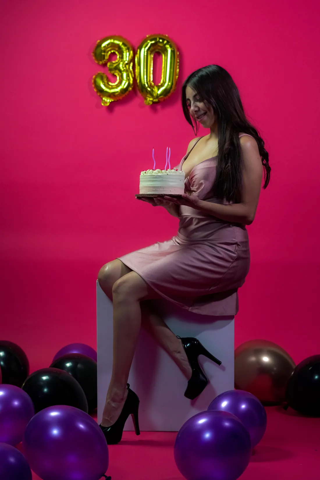 Sesión de fotos de cumpleaños en estudio con vestido rosa y números dorados sobre fondo rosa, toma 28