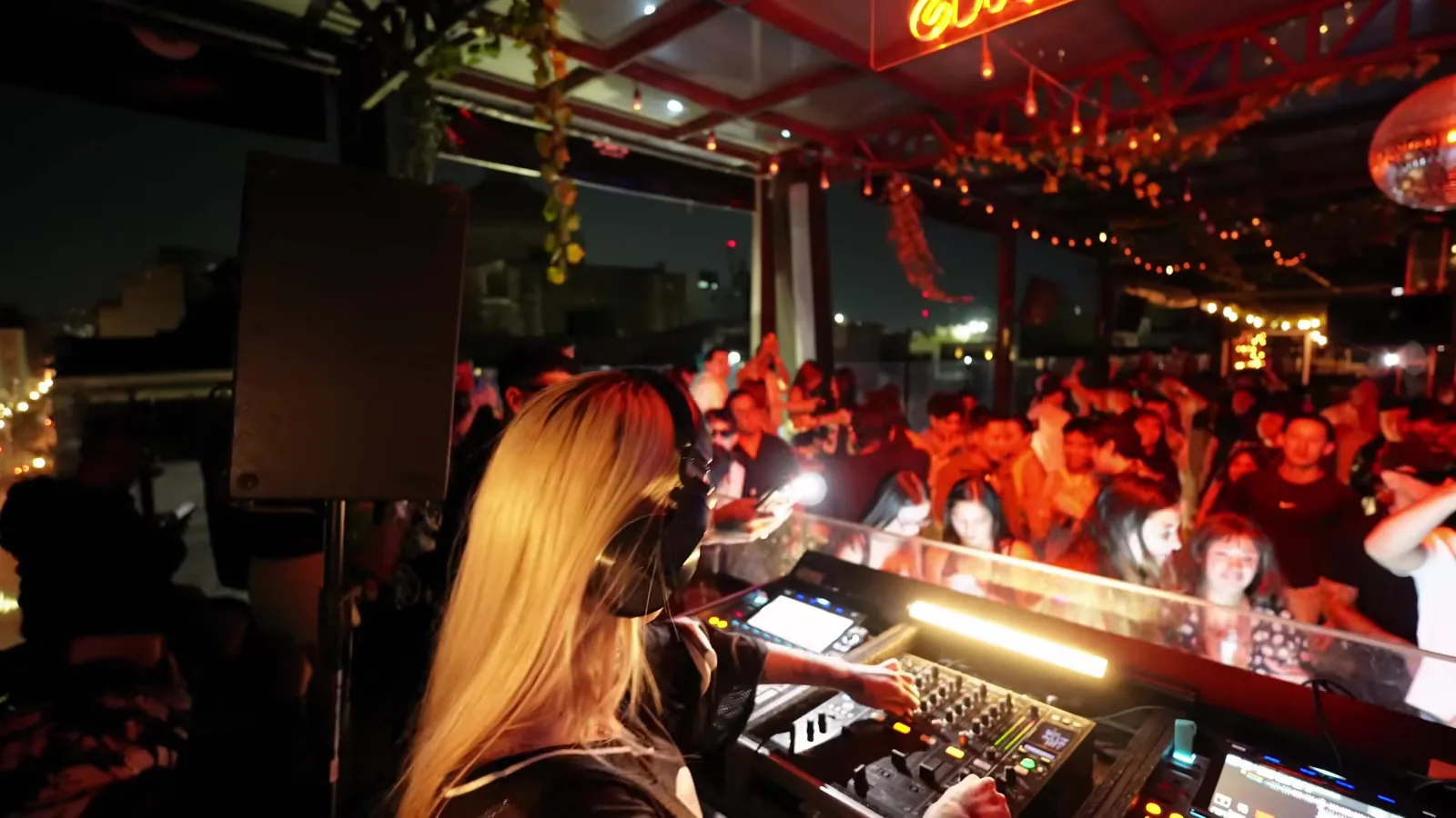 Talia Eisset tocando de espaldas frente a una pista llena en un rooftop de la CDMX