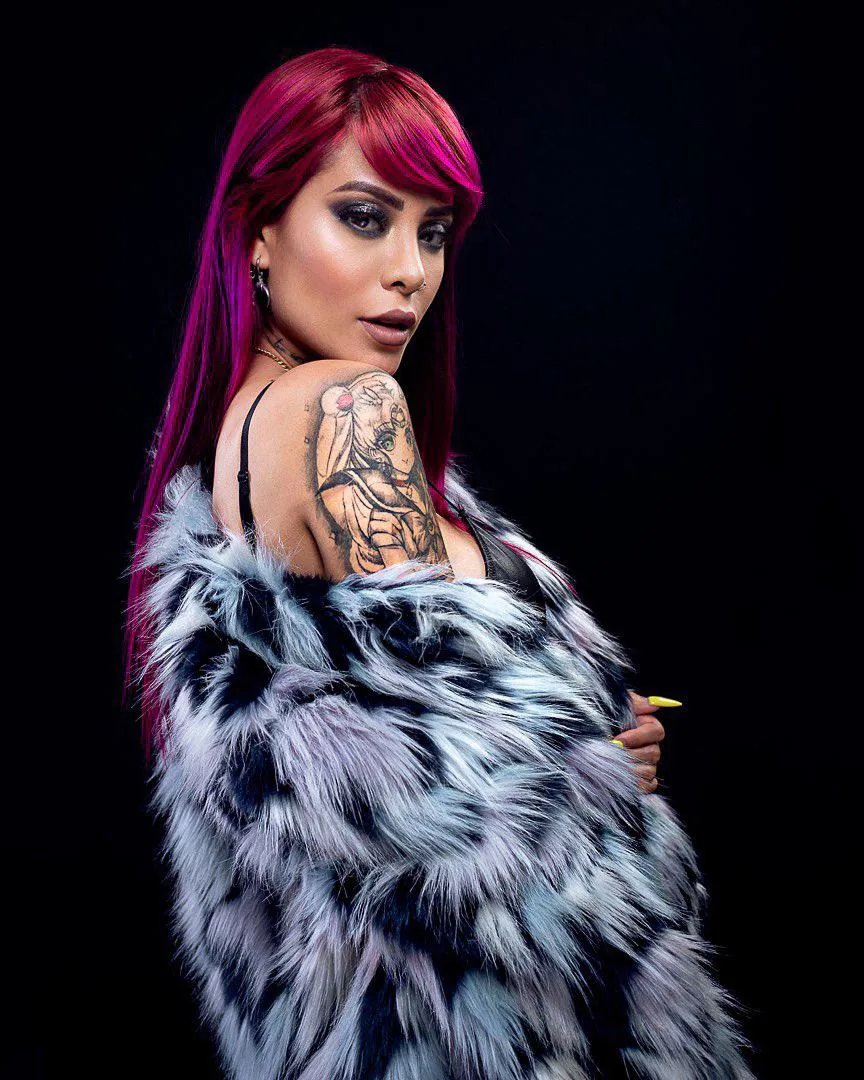 Talia Eisset en retrato de estudio con abrigo sobre fondo negro