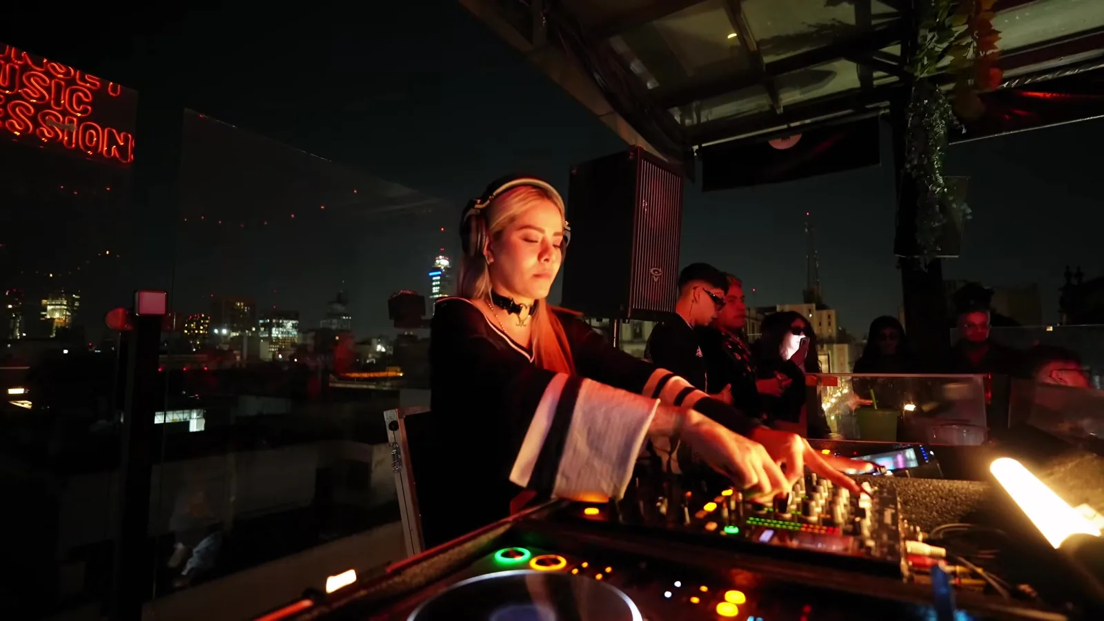 Talia Eisset mezclando de perfil con la Torre Latinoamericana de noche al fondo