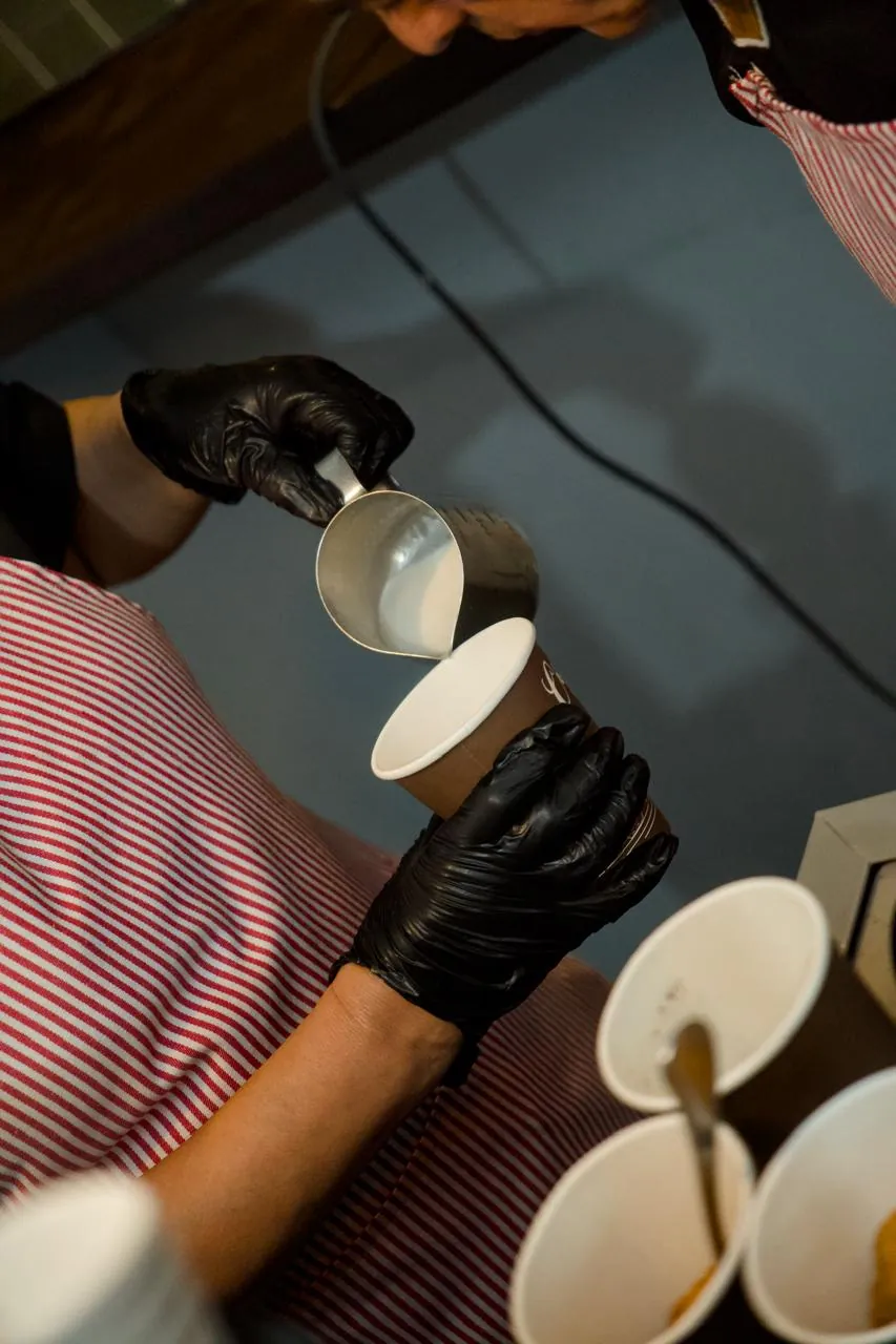 Barista sirviendo latte en barra de café para evento corporativo en CDMX