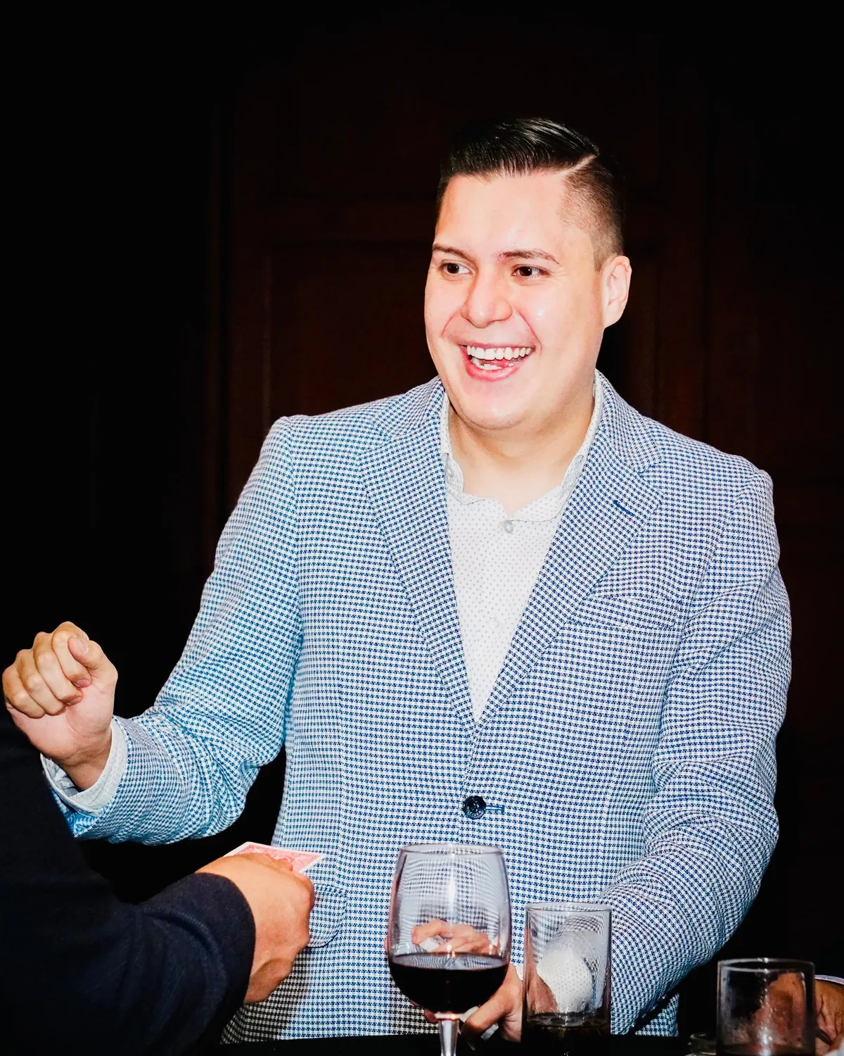 Mago Sam haciendo magia de cerca con una carta frente a un invitado en un evento corporativo en la Ciudad de México