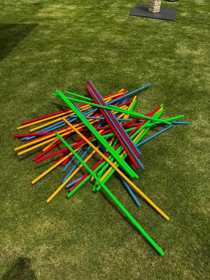 Palillos chinos gigantes de colores sobre pasto en un evento